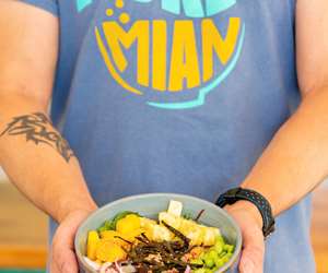 Poke Mian employee holding a bowl